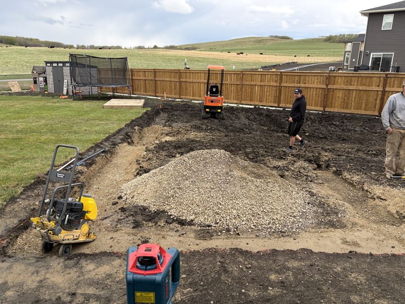 Digging out a backyard with a mini excavator before the base goes in