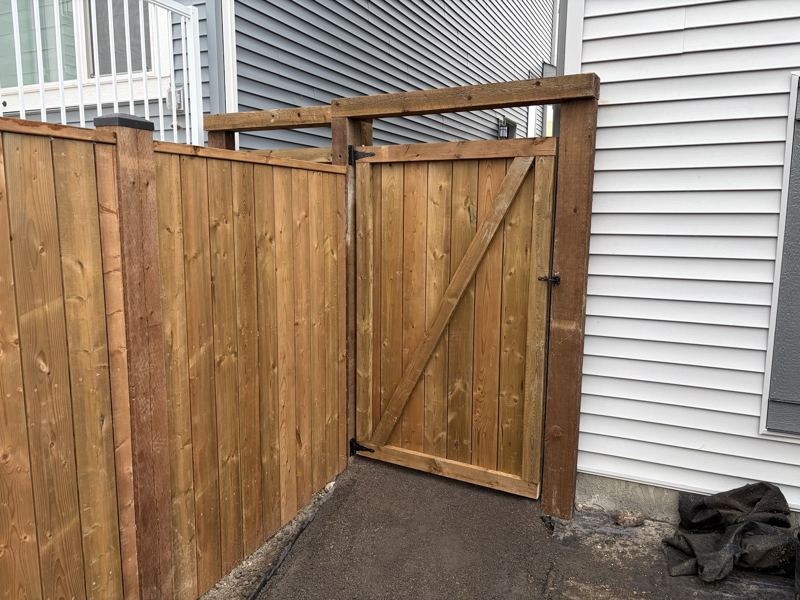 Wood fence and matching gate beside a house