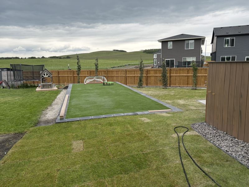 Finished yard with a new wood fence, turf and trees