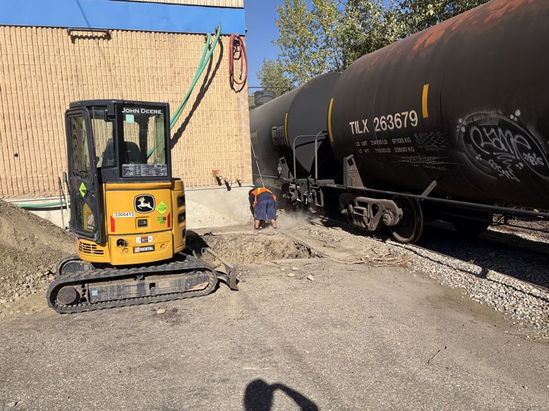 Mini excavator working beside a commercial building