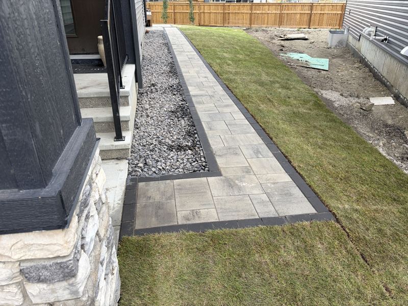Paver walkway with a dark border and fresh sod